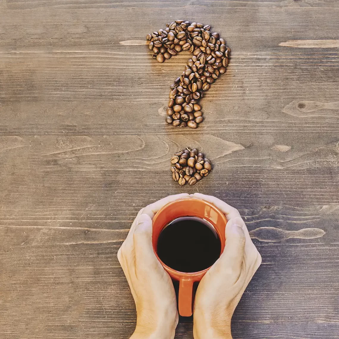 Xícara de café sobre a mesa com grãos colocados de forma decorativa