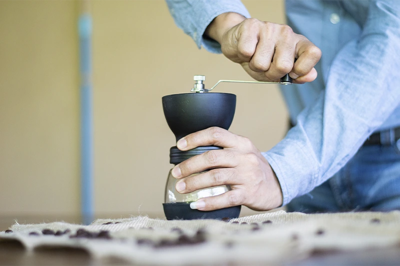 Moendo café em moedor manual