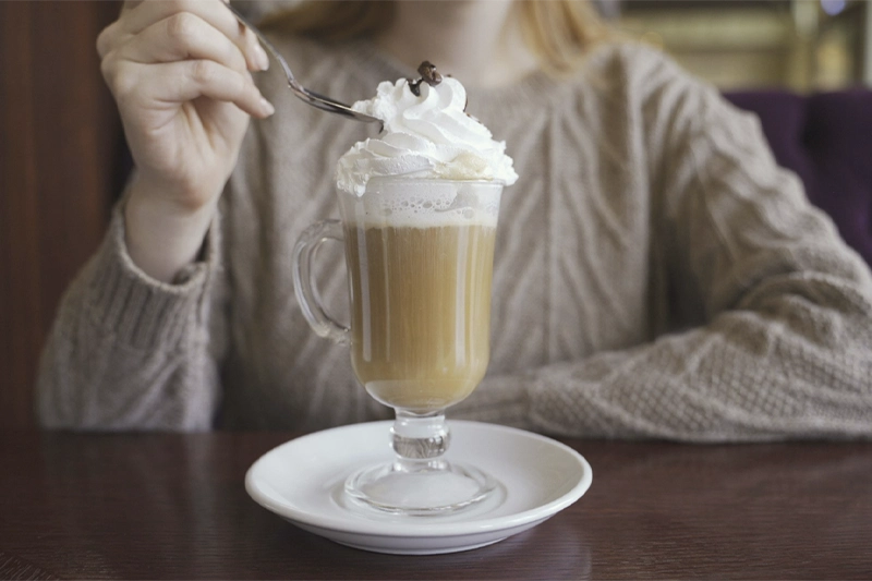 Foto de mulher tomando mocaccino em cafeteria