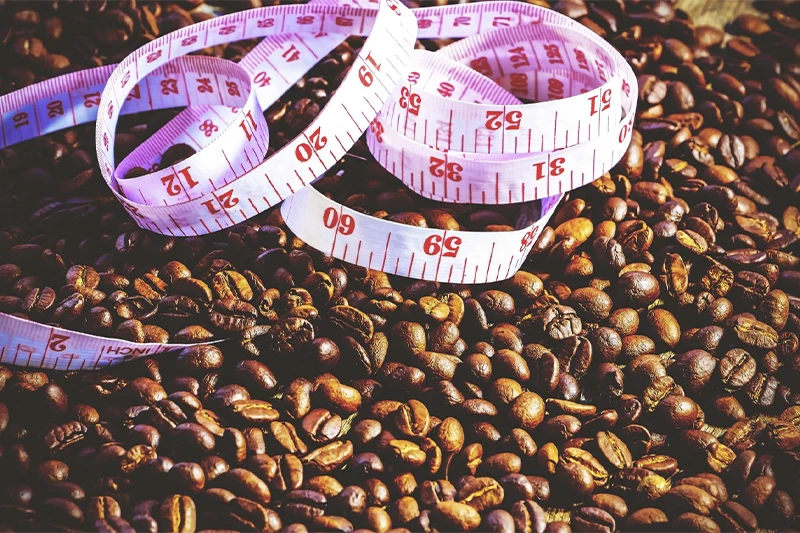 Grãos de café com fita de medição de gordura